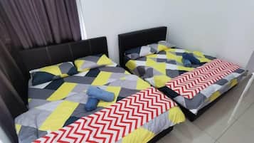 A room with two beds, each with a distinct geometric patterned bedspread.