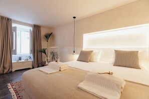 A hotel room with a large bed, bedside tables, a lamp, and a view of the outside. - Legasea Cascais (Cascais)