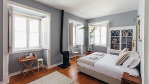 Ein Schlafzimmer mit einem Bett, einem Schreibtisch, einem Stuhl und einer Zimmerpflanze.