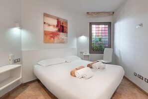 Une chambre d’hôtel avec un lit, une fenêtre donnant sur un paysage agréable, un tableau au mur et une chaise.