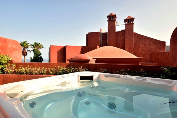 Un jacuzzi con vistas despejadas a un edificio grande y rojo al fondo.