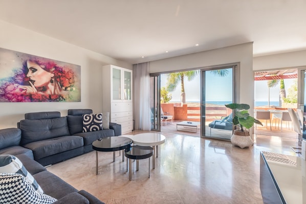 A modern living room with a sofa, coffee table, and a painting on the wall.