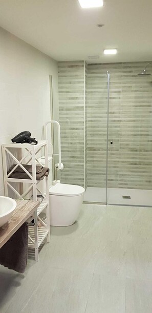 Chuveiro, secador de cabelo, bidê, toalhas de banho