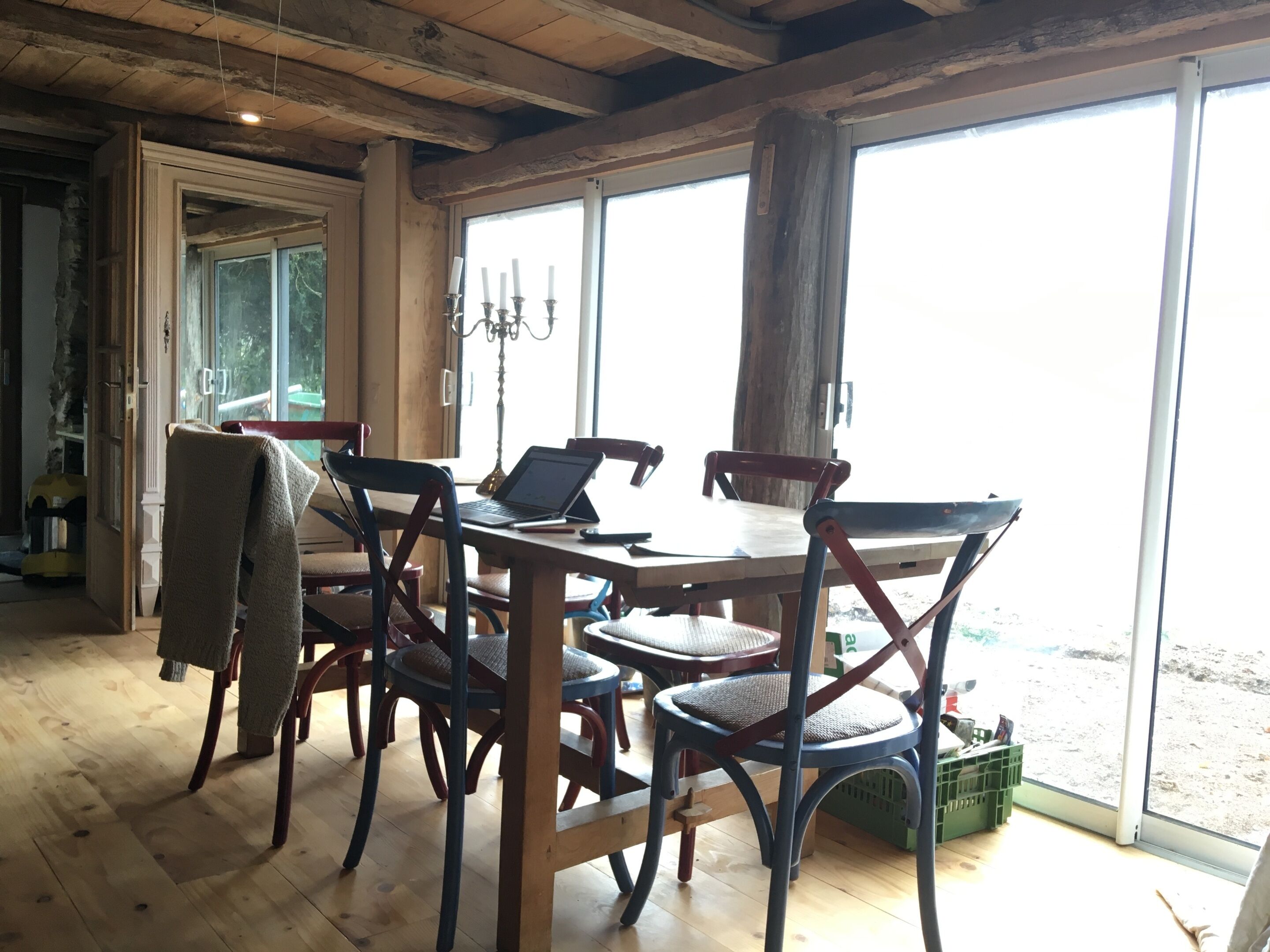 Zona pranzo con tavolo e sedie in legno, un portatile e un lampadario.