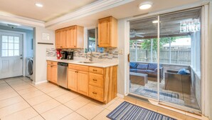 A kitchen with wooden cabinets, a dishwasher, and a coffee maker.