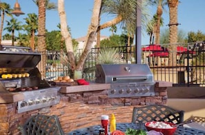 Enjoy al fresco dining at this outdoor barbecue area, featuring a grill and dining table.