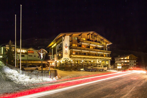 A hotel with a restaurant on the ground floor, a ski lift in the background, and a snowy landscape. - Hotel Cresta (Samnaun)