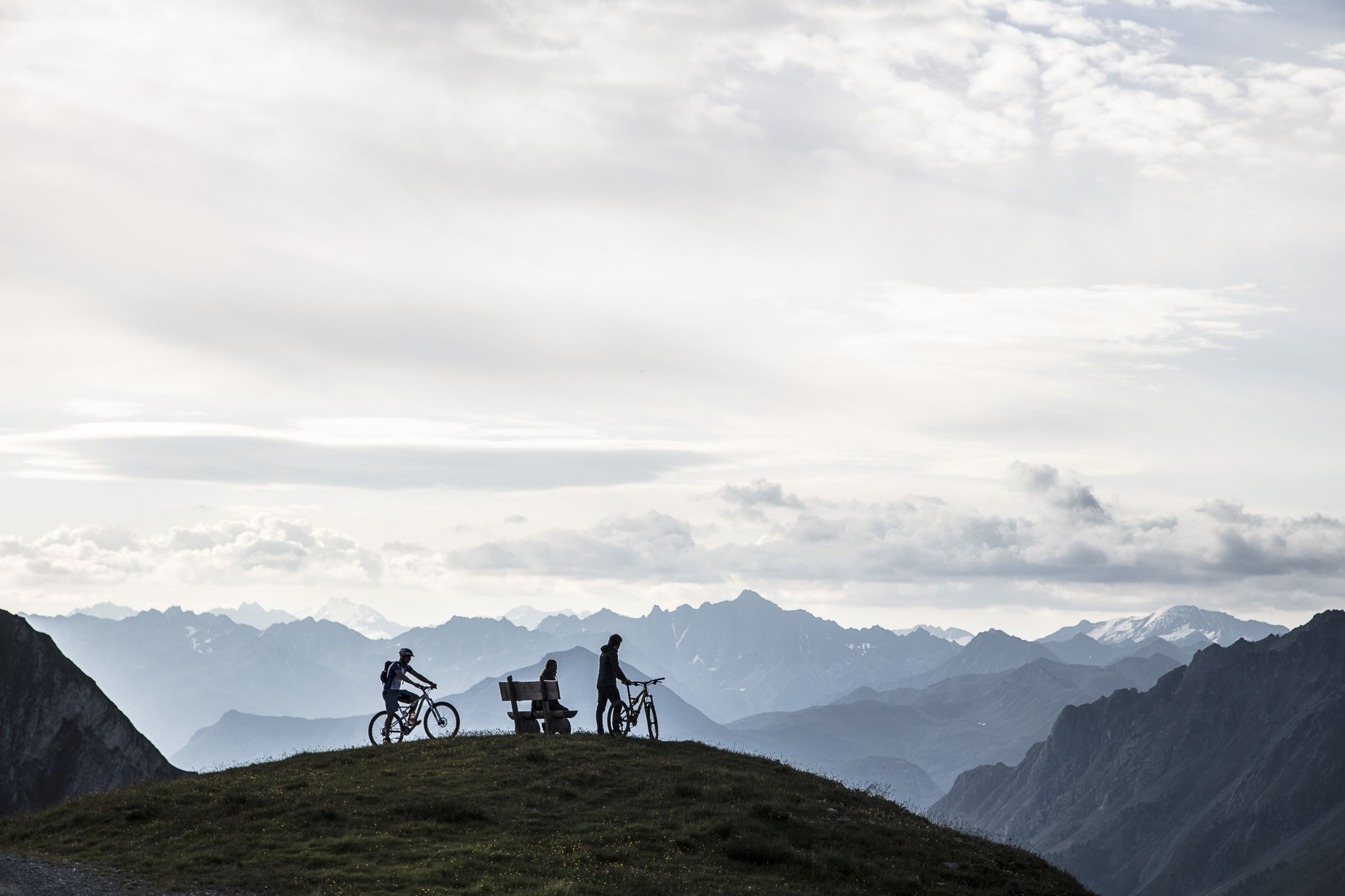 Un paysage montagneux avec deux vélos et un banc.