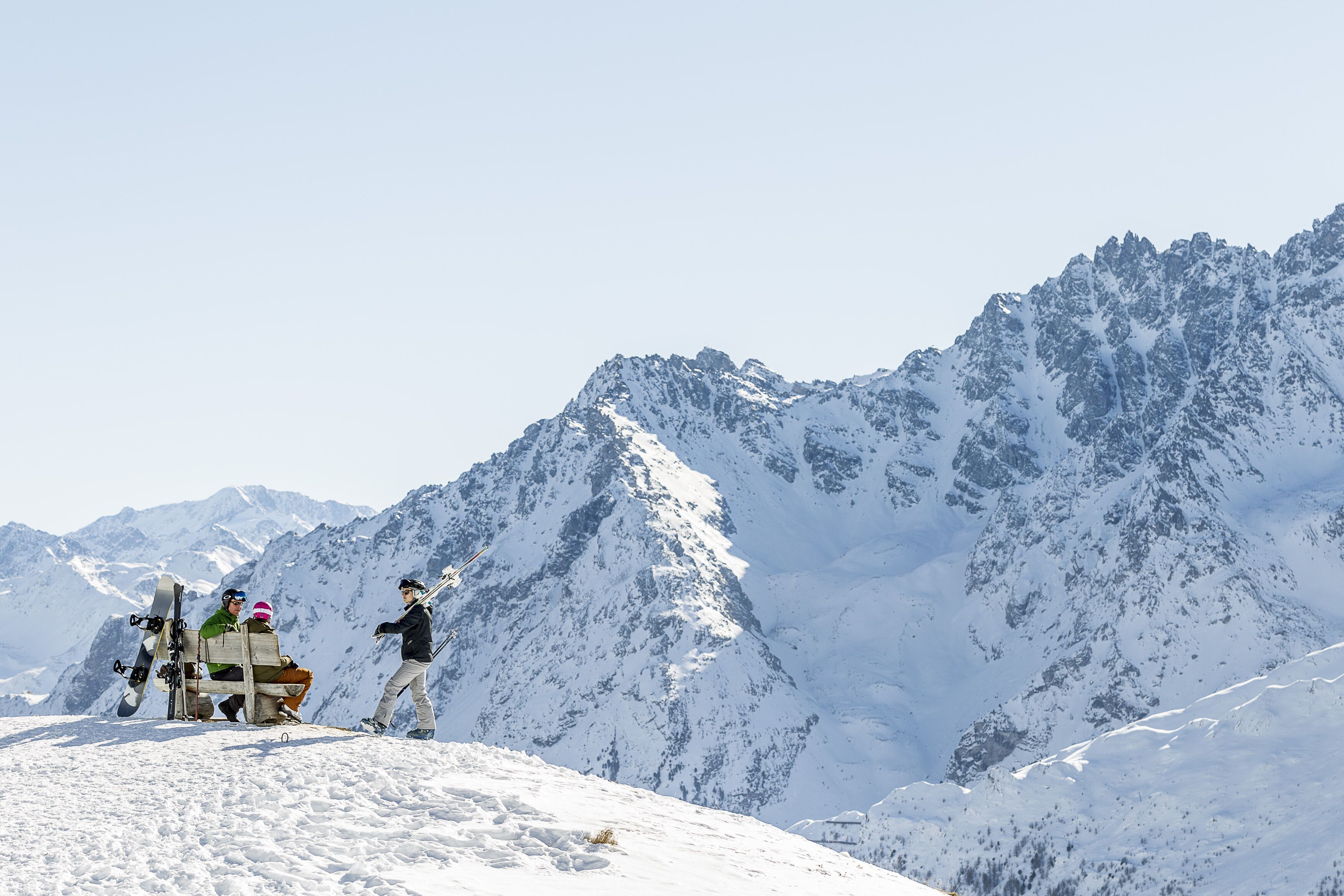 En grupp människor på ett snötäckt berg, med snowboard och skidor, vilket tyder på att det är ett skidområde.