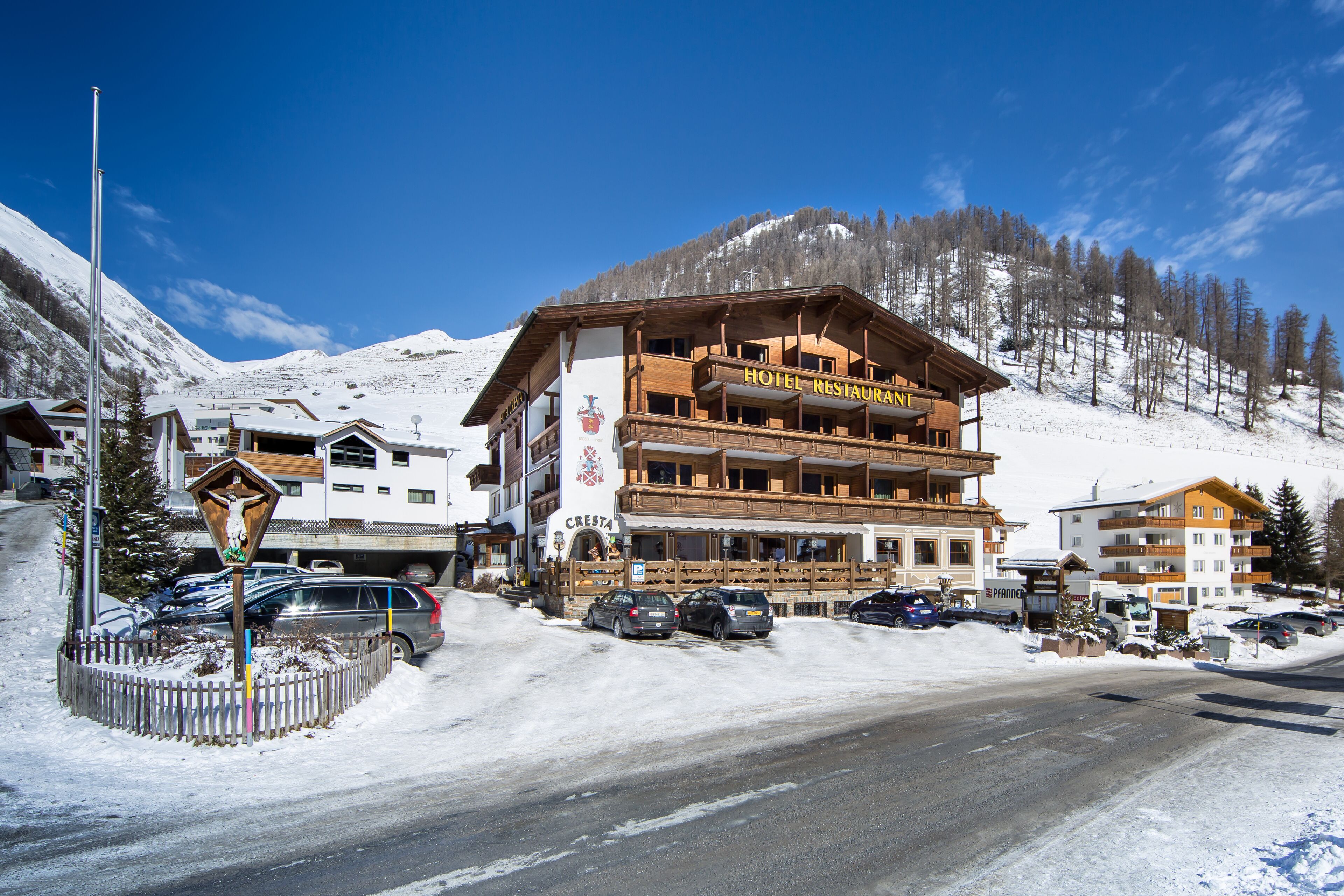 A hotel with a wooden facade, balconies, and a sign indicating it is a restaurant.