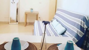 A room with a bed, a bedside table, a mirror, and a wall-mounted paddleboard. - Stella Marina - Stella Studio (Polignano a Mare)