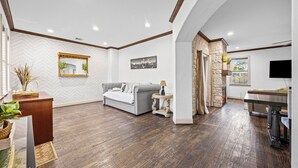 A spacious living room with a grey sofa, a coffee table, and a fireplace.