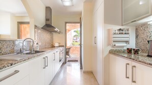 Una cocina moderna con encimeras de granito, electrodomésticos de acero inoxidable y vistas al exterior.