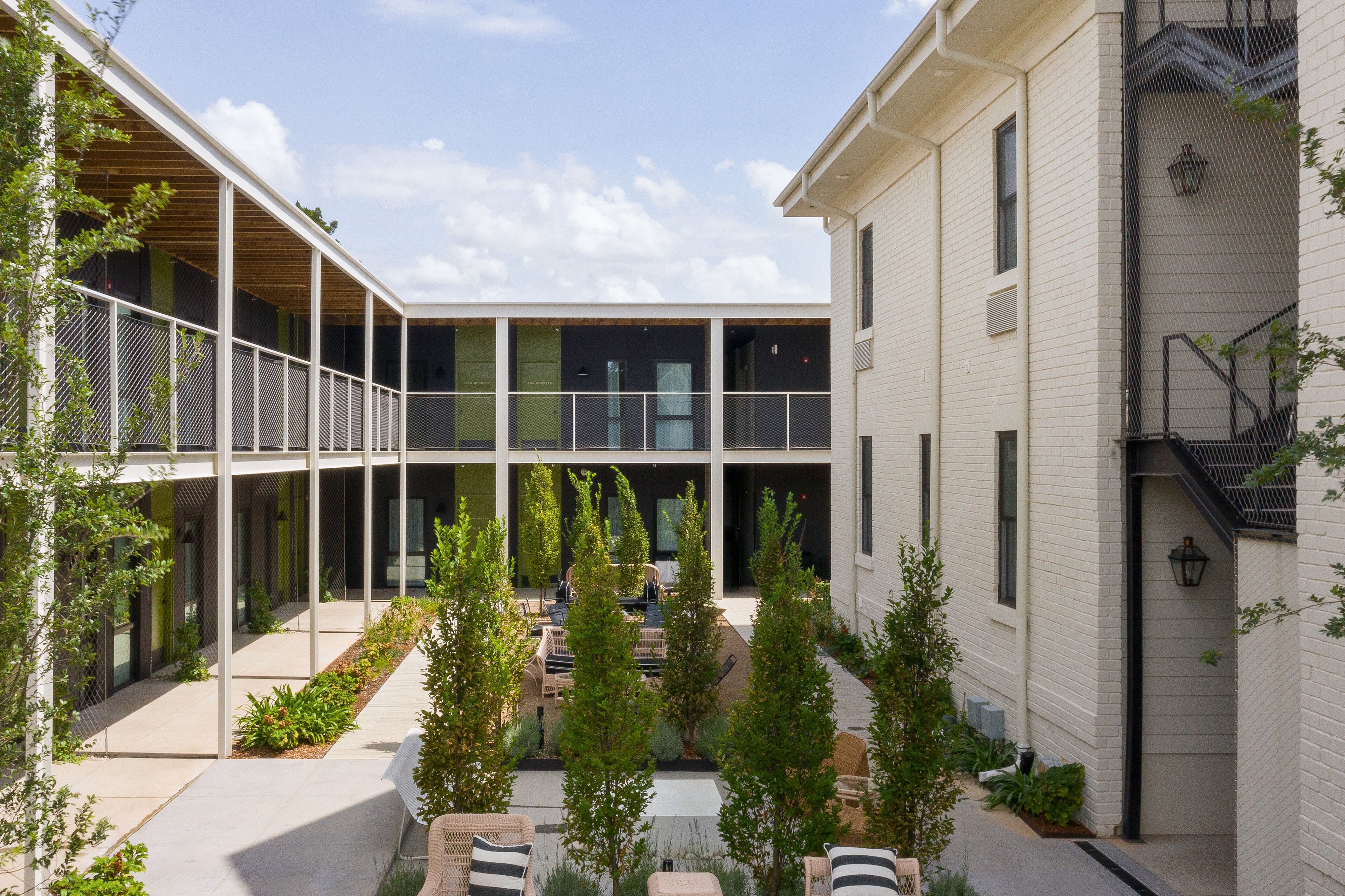 A courtyard with outdoor seating, a covered area, and a building with a brick facade.