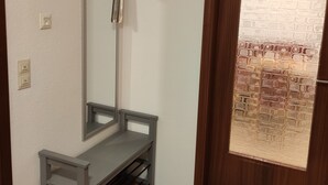 A room with a wooden door, a bench, and a wall-mounted mirror. - Geiger's apartment in the Laucherttal (Veringenstadt)