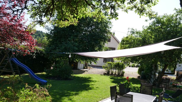 A backyard with a slide, a patio table, and chairs. - Geiger's apartment in the Laucherttal (Veringenstadt)