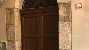 A brown wooden door with a small window above it, set in a stone wall with a number plate '12' visible. - B&B In Centro Storico Salerno (Salerno)