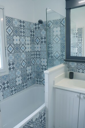 Bathtub, hair dryer, towels, toilet paper