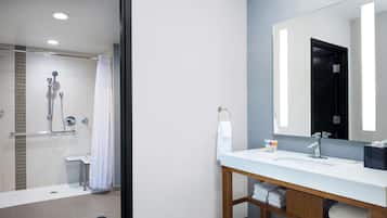 Une salle de bain moderne avec une douche, un lavabo et un miroir.