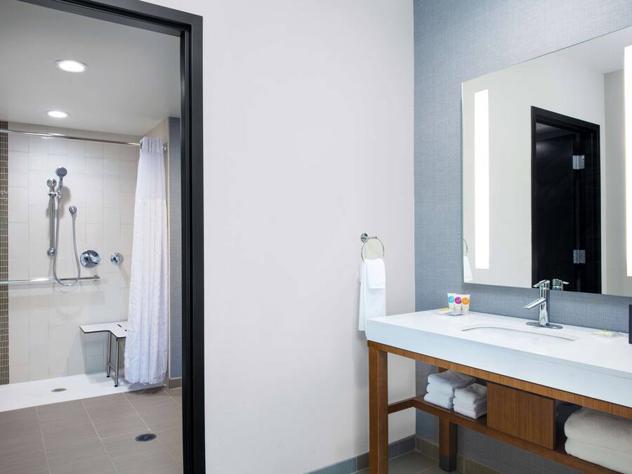 Une salle de bain moderne avec une douche, un lavabo et un miroir.