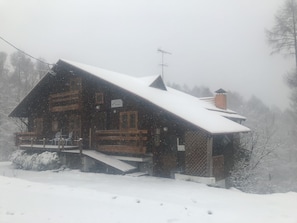 A wooden cabin with a steeply pitched roof, surrounded by snow-covered ground and trees. - Alpages Madarao (Myoko)