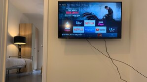 A hotel room with a mounted television displaying a streaming service interface. - Roath Retreat (Cardiff)