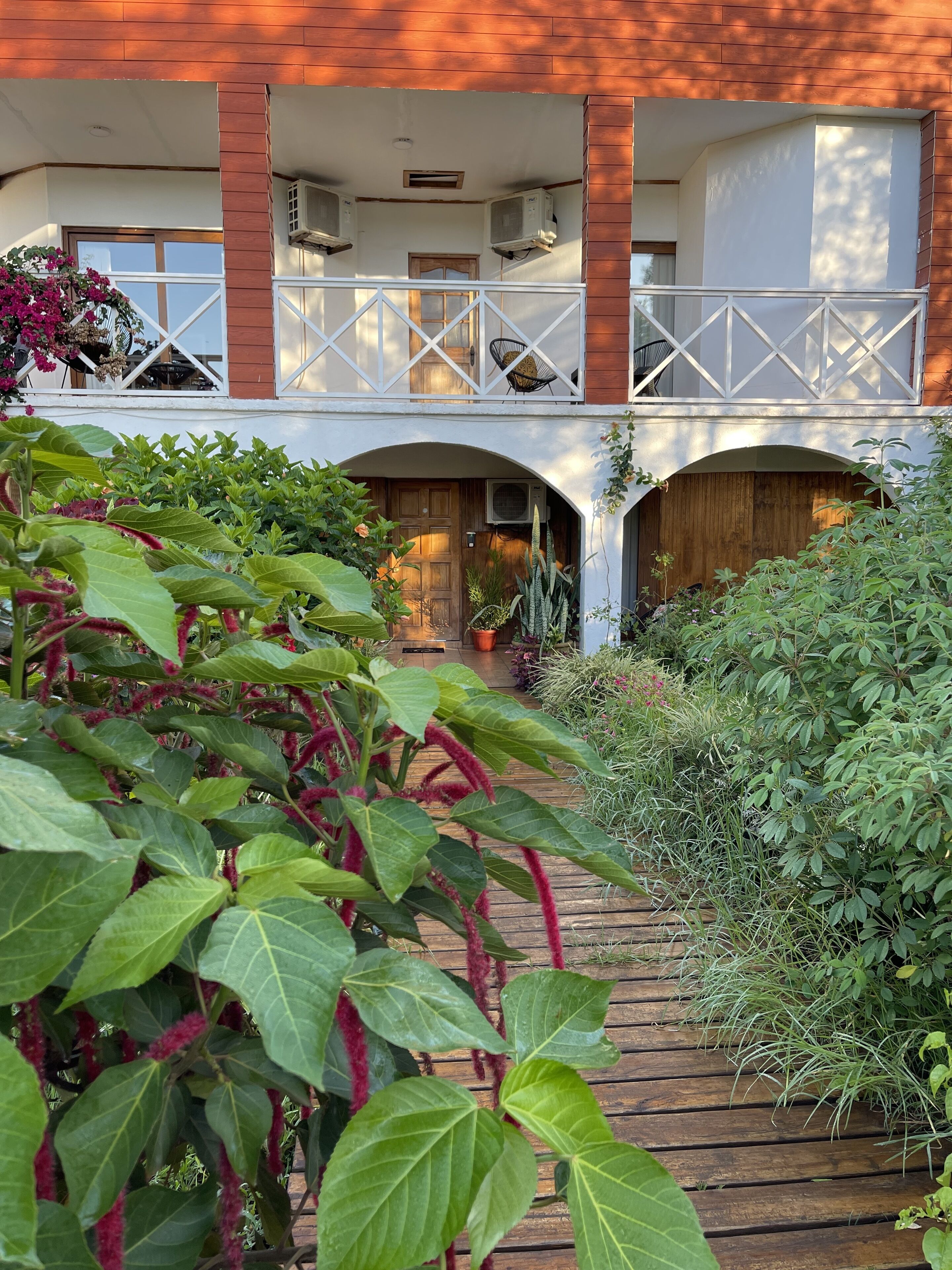 A two-story building with a wooden balcony and a covered walkway.