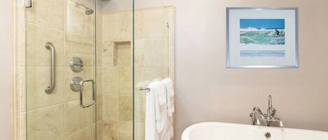 Une salle de bain avec une douche à parois de verre, une baignoire blanche et un tableau encadré au mur.