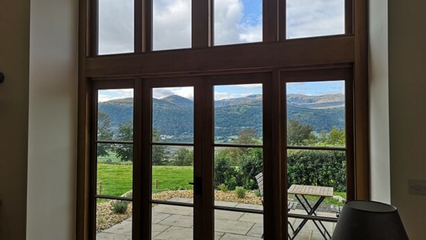 Una habitación con un ventanal grande que ofrece vistas a un paisaje verde y montañas.