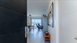 A hallway with a dark wall, a wooden bench, and a painting on the wall. - Unobstructed Ocean View - Ocean Front Condo (Sint Maarten)