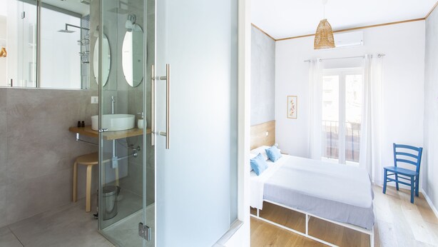 Une salle de bain moderne avec une douche à parois de verre, un lavabo blanc et un tabouret en bois.