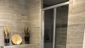 A modern bathroom with a toilet, bidet, and shower area.