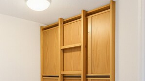 A wooden wardrobe with multiple compartments and a built-in shelf.