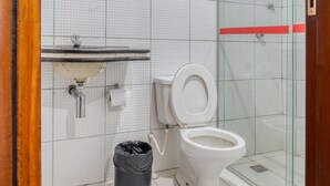 A bathroom with a white sink, toilet, and a trash bin. - Pousada Vilas Costeira (São Luís)
