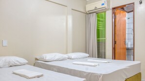 A hotel room with two beds, a bathroom with a shower, and an air conditioning unit. - Pousada Vilas Costeira (São Luís)
