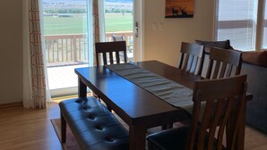 A dining area with a wooden table and chairs, a chandelier, and a view of mountains through a sliding door. - Great for ATV's and TOY'S!  Rent 6 nights and 7th is free! (Buena Vista)