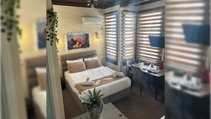Una habitación de hotel moderna con cama, mesita de noche y escritorio con silla.