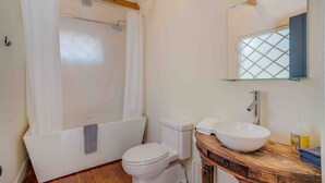 A bathroom with a shower, toilet, and sink.