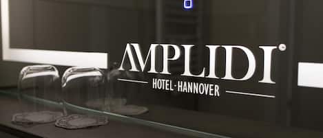 A hotel sign with the name "AMPLIDI HOTEL HANNOVER" and a glass display case with items inside.
