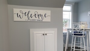 Una puerta blanca con un letrero que dice 'Welcome to the Blueberry Bungalow' arriba.