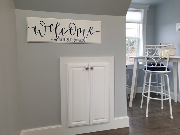Eine weiße Tür mit einem Schild, auf dem 'Welcome to the Blueberry Bungalow' steht.