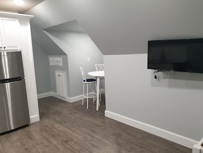 Enjoy meals in the kitchen with an oven and refrigerator, and dine at the adjacent table with a flat-screen TV above.