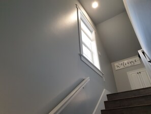 Staircase leading to a welcoming entrance with a window above and a door below.