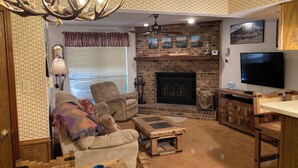 A cozy living room with a fireplace, a television, and a comfortable seating area.