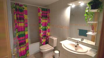 Een bad, handdoeken, toiletpapier