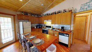 A kitchen with wooden cabinets, a central island, a refrigerator, a stove, and a dishwasher. - Round Eagle Home near the River and Park (Red River)