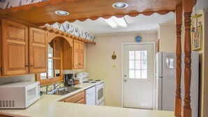 A kitchen with wooden cabinets, a white refrigerator, a microwave, and a stove. - Claim Jumper #17 Townhouse (Red River)