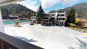 A hotel with a parking lot, a view of a lake, and mountains in the background. - Claim Jumper #17 Townhouse (Red River)