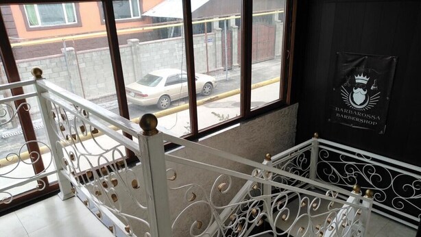 A staircase with ornate white railings and a view of a parked car outside. - Kedr Grad Inn on the way to Medeo (Almaty)