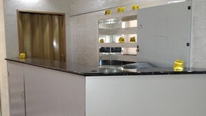 A kitchen with a countertop, cabinets, and a window with curtains. - Kedr Grad Inn on the way to Medeo (Almaty)